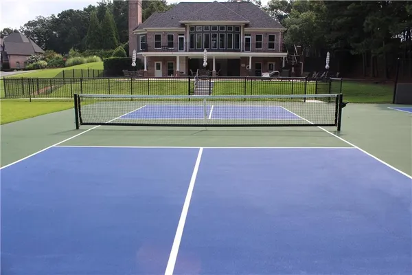 a green field with lots of trees in the background