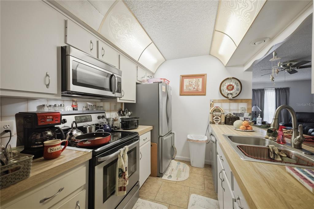 3455 Southwest 19th Street Ocala, FL 34474 - Photo 9 of 17 a kitchen with stainless steel appliances granite countertop a stove a sink dishwasher and a refrigerator with wooden floor
