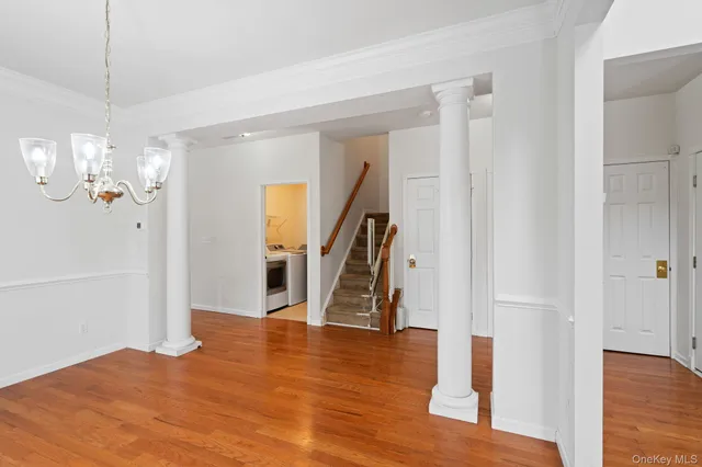 a view of a room with wooden floor staircase and a kitchen