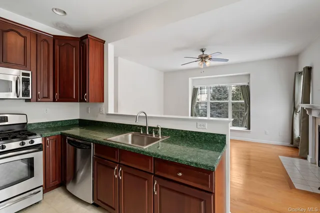 a kitchen with granite countertop a sink a counter top space appliances and cabinets