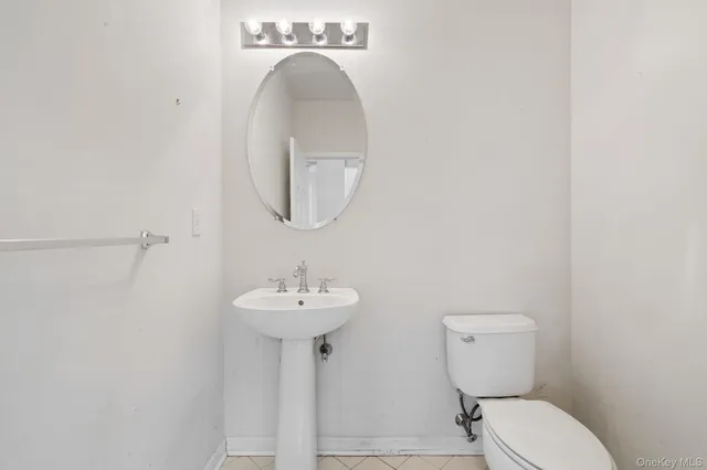 a bathroom with a sink toilet and a mirror