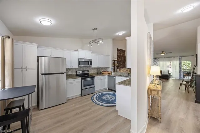 a kitchen with a refrigerator and a stove top oven