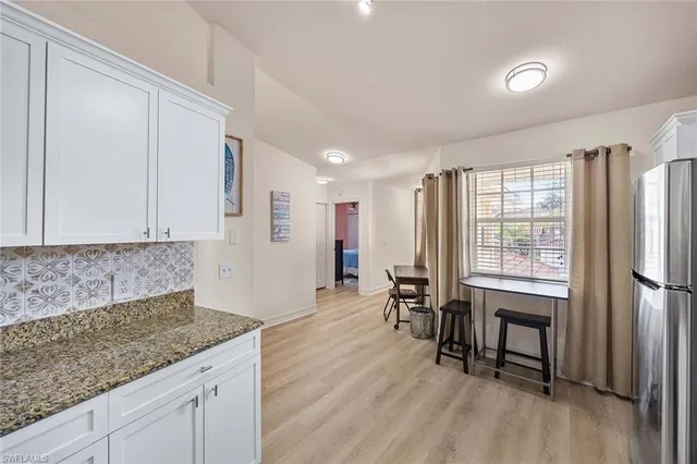 a kitchen with stainless steel appliances granite countertop a refrigerator a stove and a wooden floors