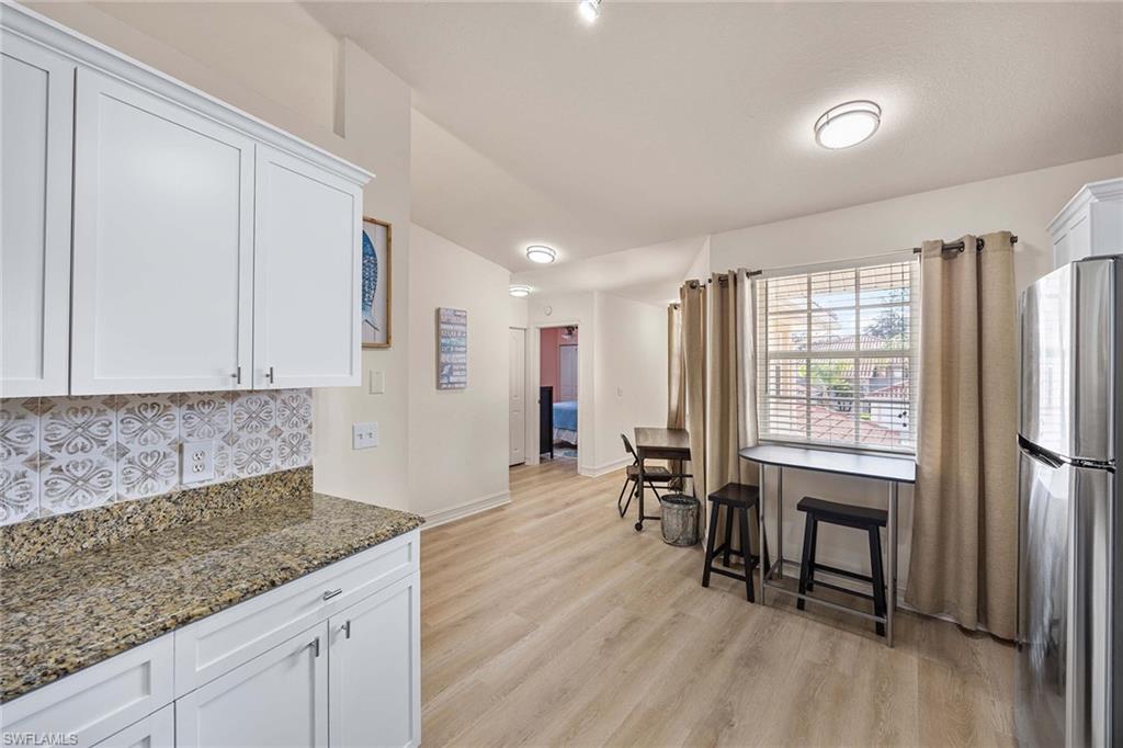 640 Luisa Lane, Unit 8044 Naples, FL 34104 - Photo 18 of 46 a kitchen with stainless steel appliances granite countertop a refrigerator a stove and a wooden floors