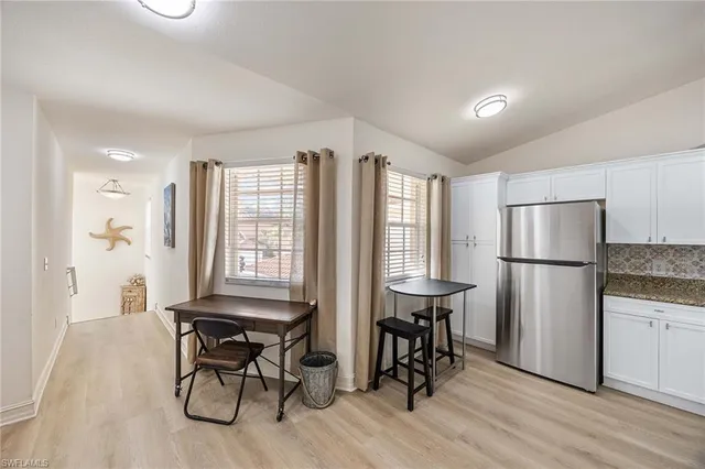 a view of a kitchen with furniture and a refrigerator