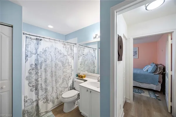 a bathroom with a granite countertop sink a toilet and a shower