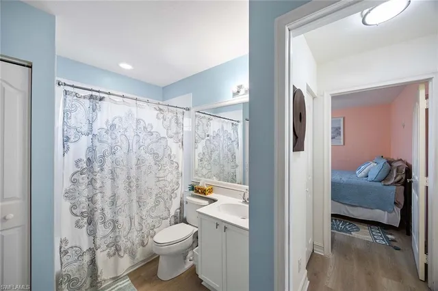 a bathroom with a granite countertop sink a toilet and a shower
