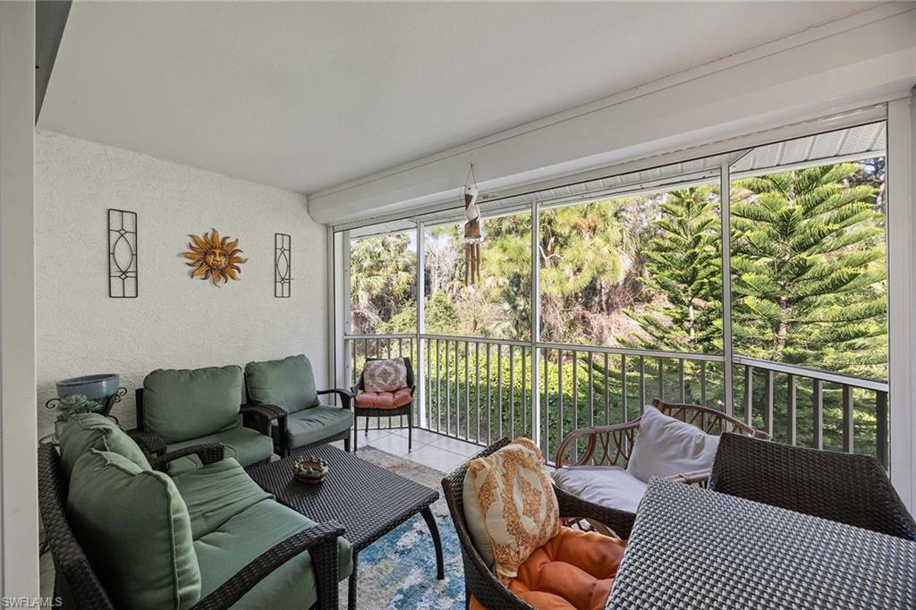 640 Luisa Lane, Unit 8044 Naples, FL 34104 - Photo 30 of 46 a living room with furniture and a floor to ceiling window