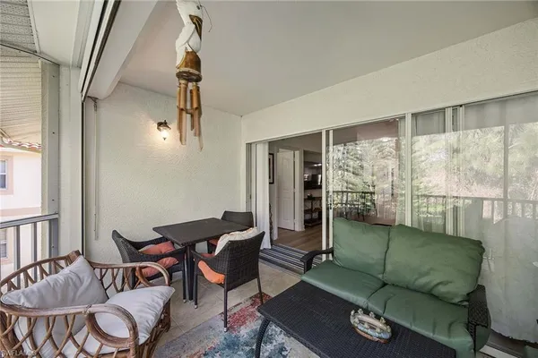 a living room with furniture and a floor to ceiling window