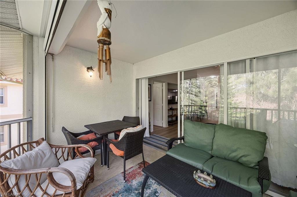 640 Luisa Lane, Unit 8044 Naples, FL 34104 - Photo 31 of 46 a living room with furniture and a floor to ceiling window