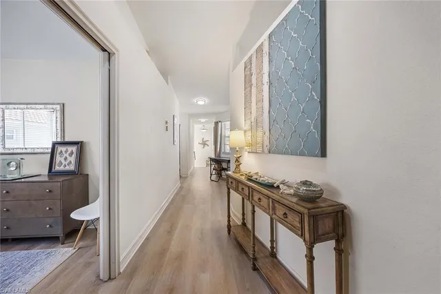 a view of a hallway with a livingroom and a window