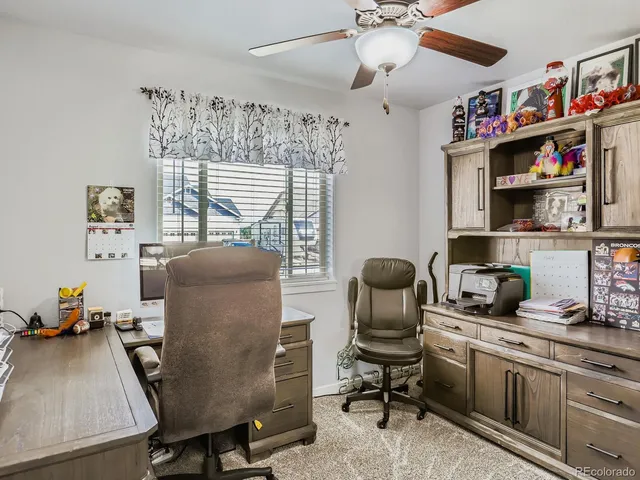 a view of a workspace with furniture and a window
