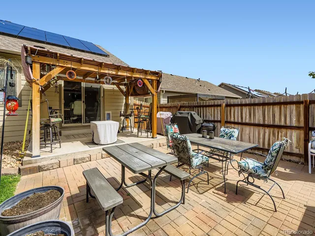 a view of a patio with table and chairs with wooden floor and fence