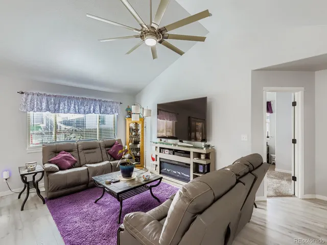 a living room with furniture a flat screen tv and a window