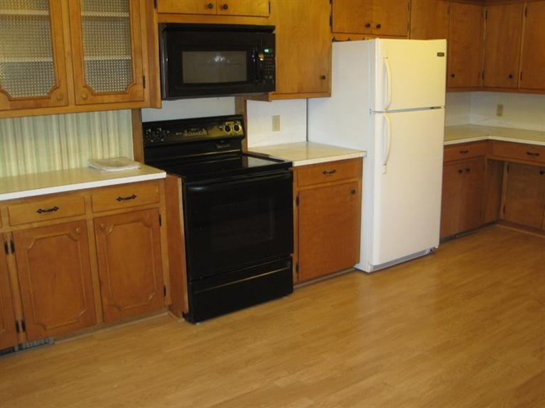 1201 16th Street Ralls, TX 79357 - Photo 6 of 10 a kitchen with a refrigerator stove and microwave