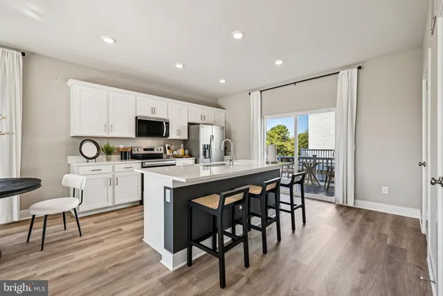 a kitchen with a table chairs microwave and cabinets