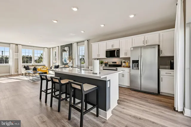 a kitchen with kitchen island a refrigerator stove microwave and cabinets