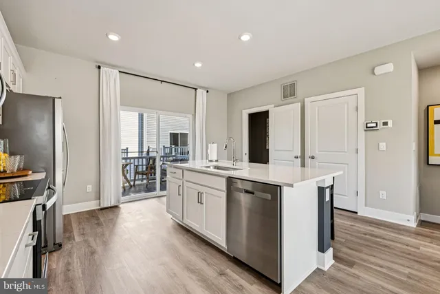 a kitchen with sink cabinets and wooden floor