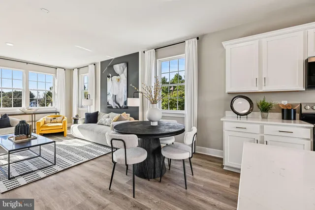 a view of a dining room with furniture a rug and wooden floor