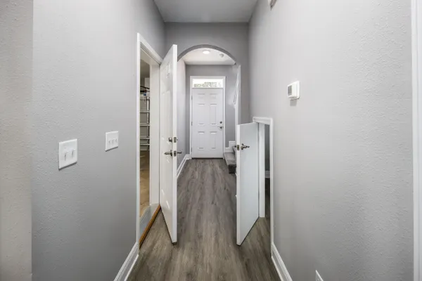 a view of a hallway with wooden floor and staircase