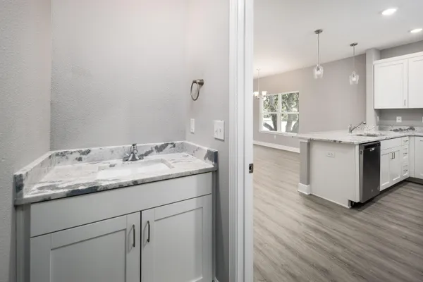 a kitchen with a sink cabinets and wooden floor