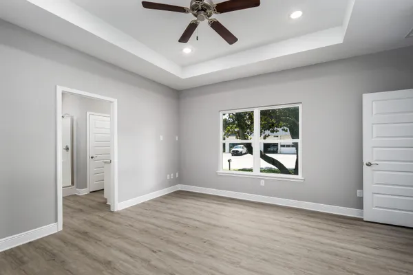 an empty room with wooden floor and windows