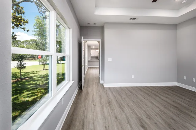 a view of a room with wooden floor and windows