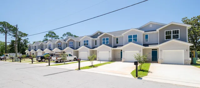 a front view of multiple houses with yard