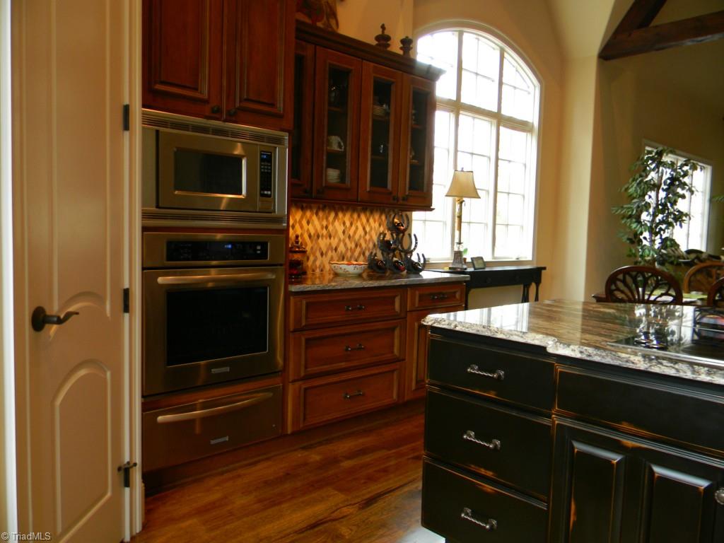 820 Pinebrook School Road Mocksville, NC 27028 - Photo 19 of 28 Kitchen with hardwood floors, double pantries, large island with glass cooktop, Kitchenaid appliances, and warming drawer.