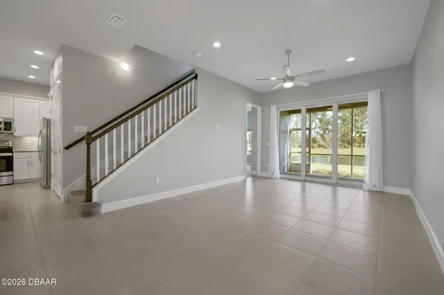 a view of an empty room with glass door and stairs