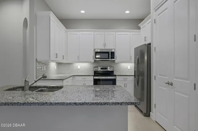 a kitchen with granite countertop a refrigerator and a sink