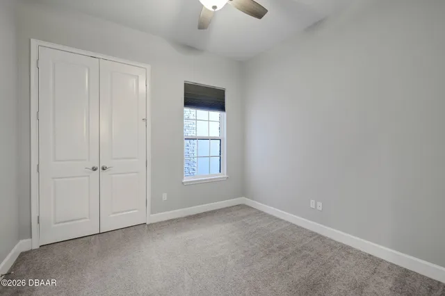 an empty room with chandelier fan