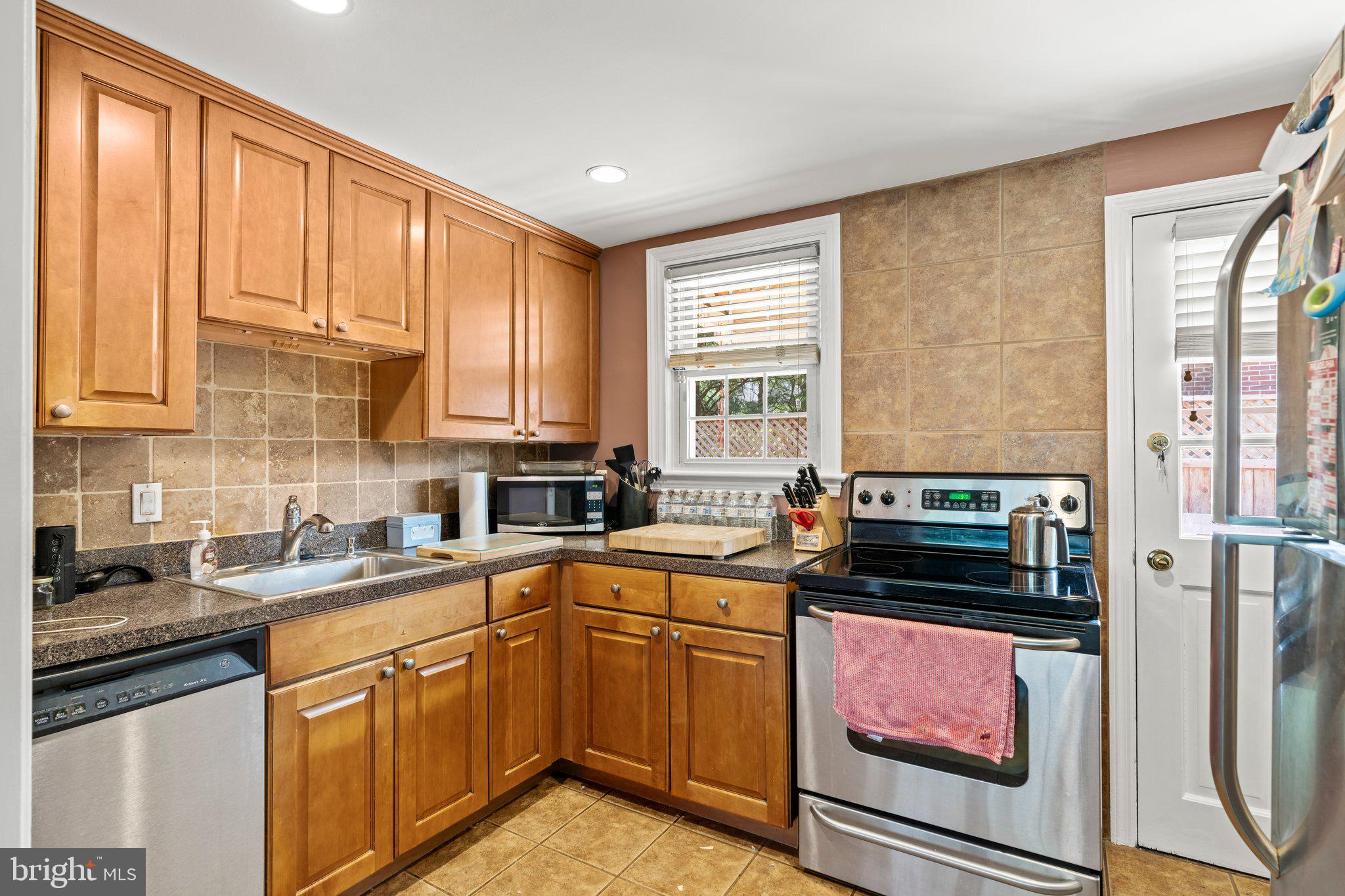 827 Dover Road Wynnewood, PA 19096 - Photo 10 of 23 a kitchen with stainless steel appliances a stove sink refrigerator and cabinets