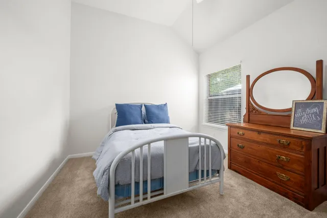 a bedroom with a bed a dresser and a window