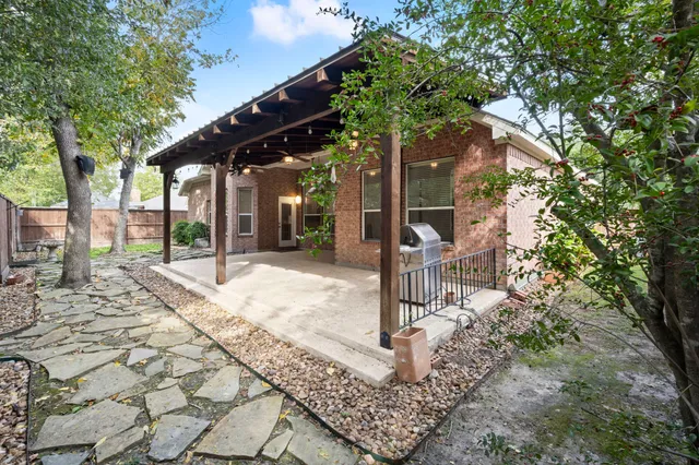 a front view of a house with a tree