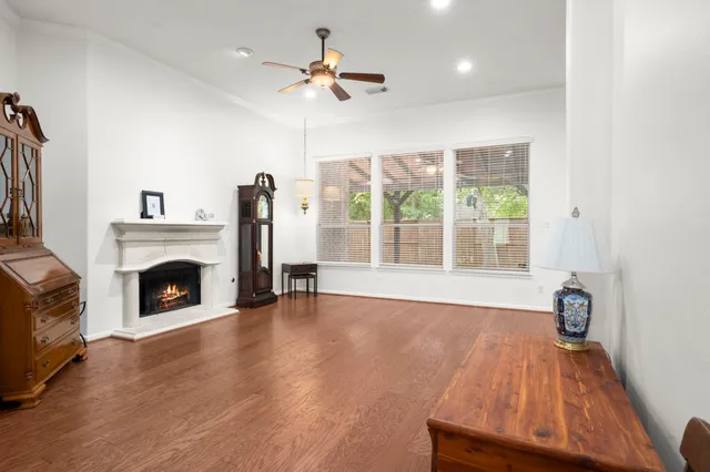 a view of a livingroom with a fireplace wooden floor and fan