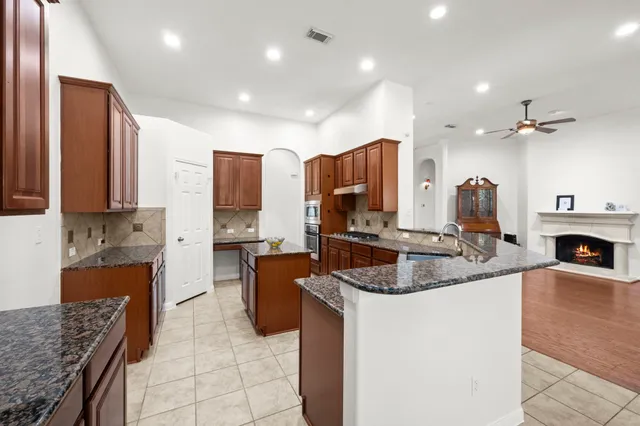 a kitchen with stainless steel appliances granite countertop a sink stove and refrigerator