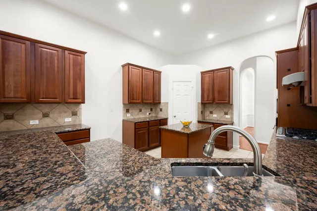 a kitchen with stainless steel appliances a stove a sink cabinets and a refrigerator