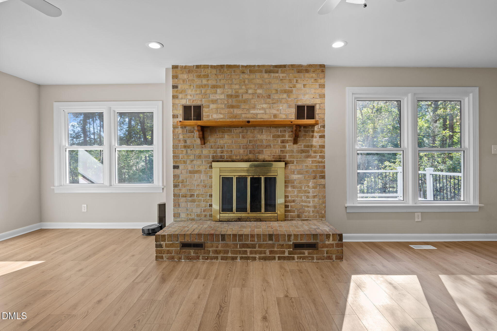 729 Wimberly Road Apex, NC 27523 - Photo 21 of 61 an empty room with windows fireplace and wooden floor