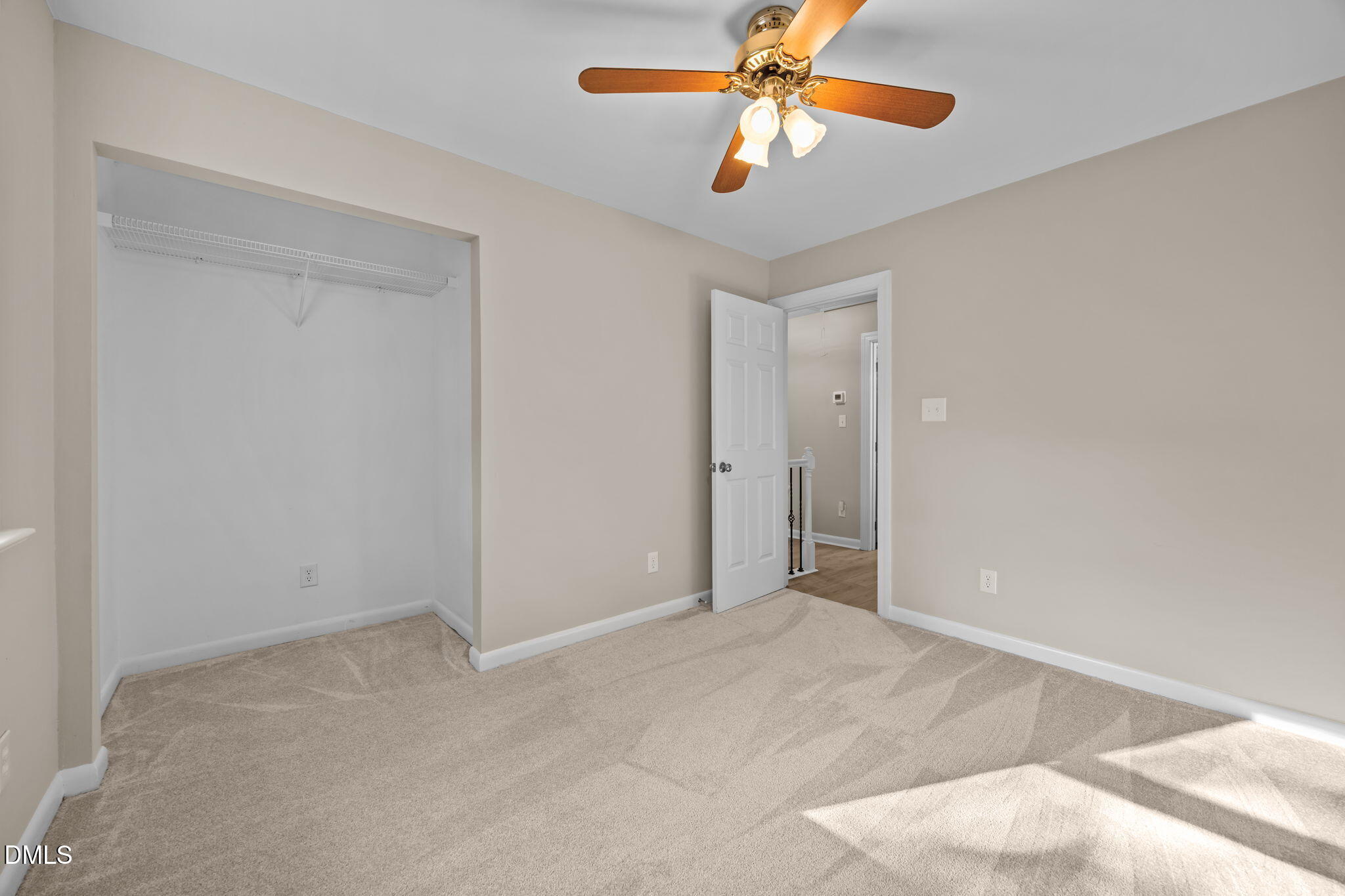 729 Wimberly Road Apex, NC 27523 - Photo 29 of 61 an empty room with closet and a chandelier fan