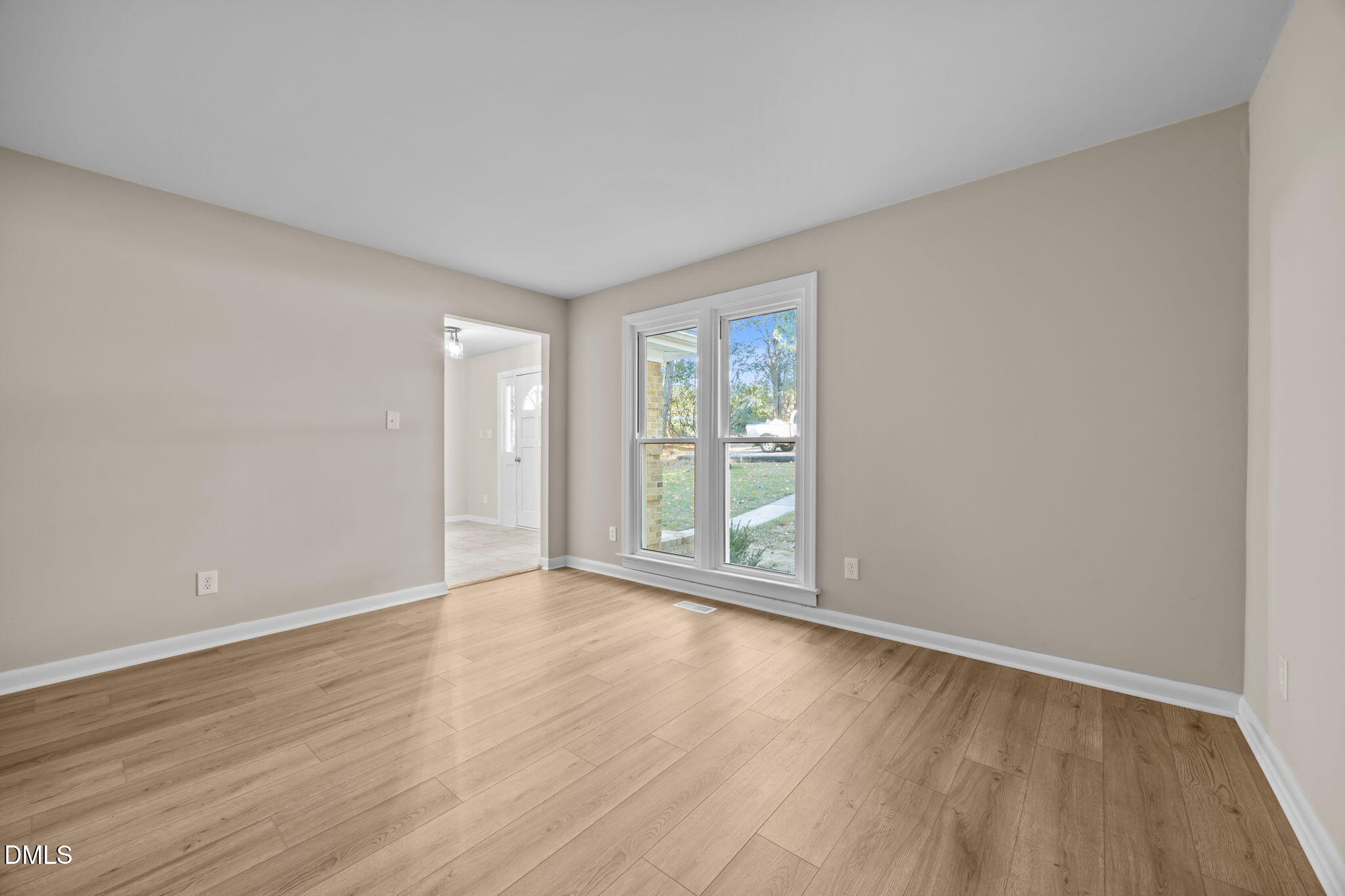 729 Wimberly Road Apex, NC 27523 - Photo 8 of 61 a view of an empty room with wooden floor and a window