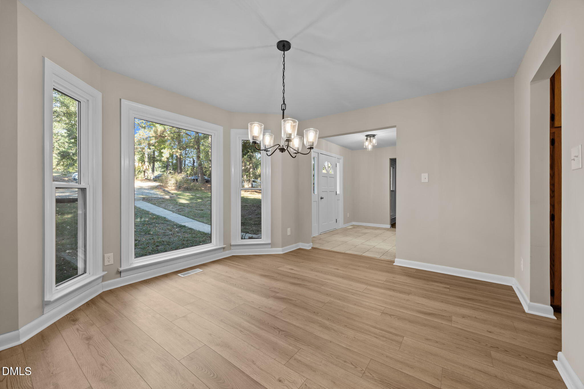 729 Wimberly Road Apex, NC 27523 - Photo 10 of 61 a view of a room with wooden floor chandeliers and kitchen view