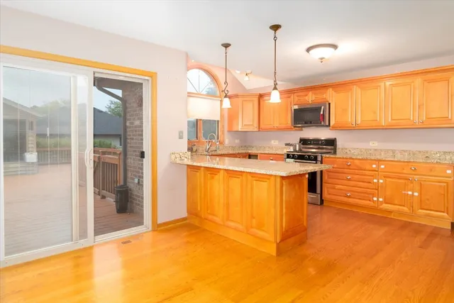 a kitchen with stainless steel appliances granite countertop a stove a sink and a refrigerator