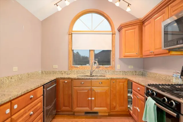 an open kitchen with granite countertop a stove a sink and a granite counter tops