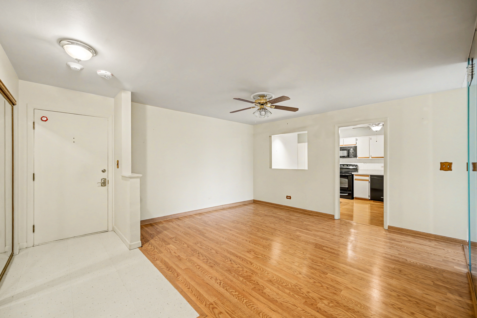40 South Main Street, Unit 4A Glen Ellyn, IL 60137 - Photo 2 of 25 a view of an empty room with wooden floor and a kitchen