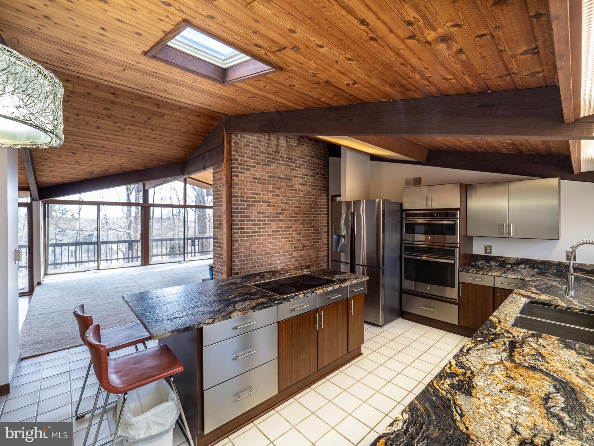 14805 Mockingbird Drive Darnestown, MD 20874 - Photo 14 of 35 a kitchen with stainless steel appliances kitchen island granite countertop a stove and a refrigerator