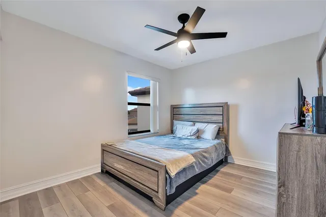 a bedroom with a bed and a ceiling fan