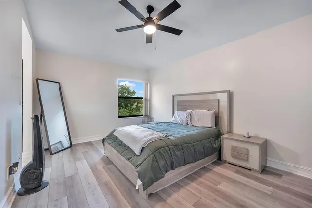 a bedroom with a bed and a ceiling fan
