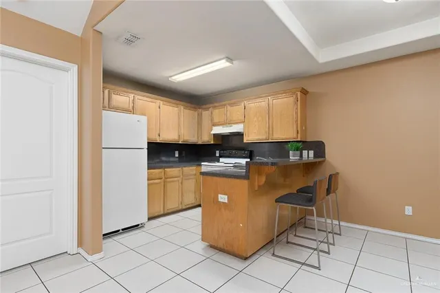 a kitchen with cabinets and a refrigerator