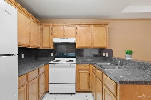 a kitchen with granite countertop white cabinets and white appliances